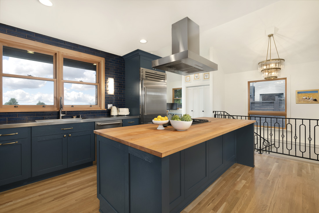 A kitchen with warm wood incorporated in the window frame, the island counter, and the flooring is a great example of  2025 interior design trends. 