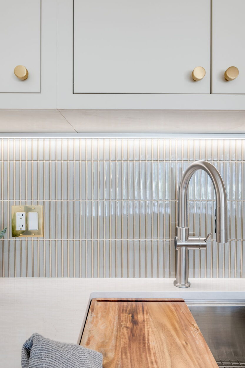 Copper cabinet pulls, a gold switch plate, and a stainless steel faucet in this kitchen exemplify 2025 home remodeling design trends by mixing metals. 