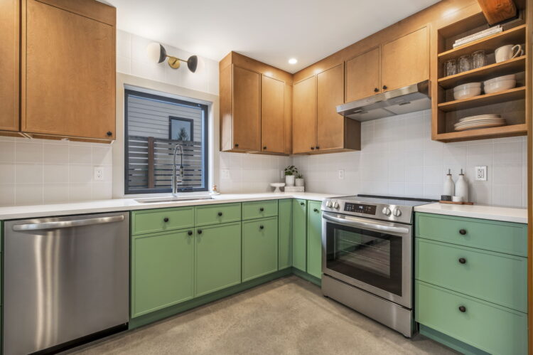 major remodel open floorplan kitchen with green lower cabinets and wood uppers